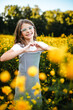 © Maria Manco/Stocksy - Preteen smiles at camera in wildflower field