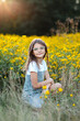 © Maria Manco/Stocksy - Preteen smiles at camera in wildflower field