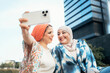 © Santi Nuñez/Stocksy - Portrait of happy muslim women friends making selfie together