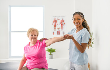 Wall Mural - Black physiotherapist helping senior woman in clinic. Elderly woman undergoing physiotherapy treatment for injury