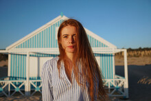 Portrait of redheaded woman in a blue dress near seaside
