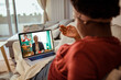 © Davor - Woman having a video call with financial advisor on laptop at home