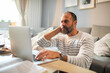 © Davor - Middle aged Caucasian man using laptop at home