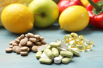 Dietary supplements. Piles of different pills near food products on light blue wooden table, closeup