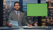 © stockbusters - Breaking news reporter talking in front chroma key monitor tv studio closeup