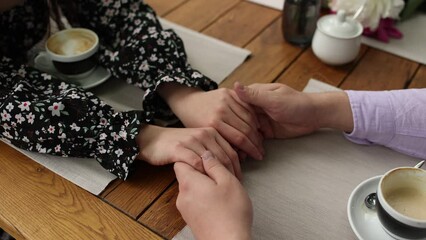 Poster - a man holds a woman's hands at a table in a restaurant on a date