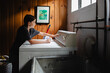 © Maria Manco/Stocksy - Tween loads washing machine with laundry
