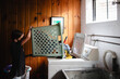 © Maria Manco/Stocksy - Tween loads washing machine with laundry