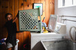 © Maria Manco/Stocksy - Tween loads washing machine with laundry