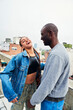 © Sergio Kleiman/Stocksy - Multiracial young couple laughing on a terrace.