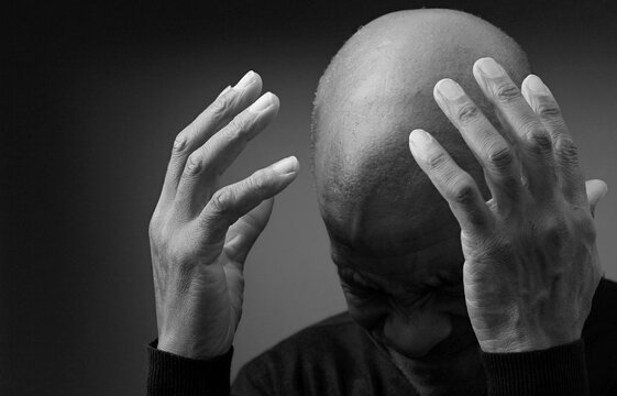 man praying to god with hands together worshiping God Caribbean man praying with people stock image stock photo	