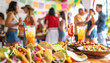 Cinco de Mayo party with food and drinks in the foreground and a group of people celebrating