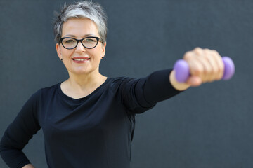 Wall Mural - An active Caucasian senior woman enjoys fitness, radiating happiness during outdoor workouts and gym sessions.