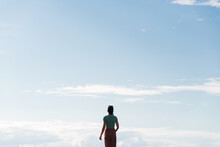 Standing woman looking at luminous blue sky