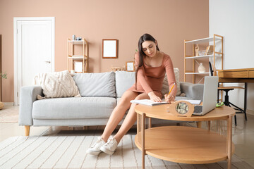 Sticker - Young pregnant woman writing in notebook at home. Maternity Benefit concept