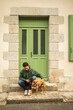 © Lupe Rodríguez/Stocksy - young man with his dog at the entrance of house