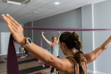 Active Woman Exercising In Indoor Gym With Raised Arms