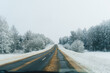 © Ivan Haidutski/Stocksy - Winter Road Trip.Snowy forest drive on a slippery empty road.