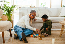 Grandmother and grandson playing with toys at home