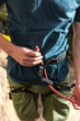 © Manu Prats/Stocksy - Rock climber tying knot before rock climbing