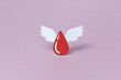 © Yaroslav Danylchenko/Stocksy - Red papercraft blood droplet with two white wings in studio
