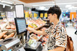 © Alvaro Lavin/Stocksy - Woman weighing fruit in the supermarket.
