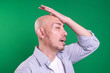 Forgetful Mature Man. Regrets wrong doing slapping hand on head having a duh moment isolated on green background. 