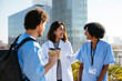 © BONNINSTUDIO/Stocksy - Medical team during conversation on hospital terrace
