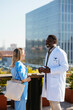 © BONNINSTUDIO/Stocksy - Medical team during conversation on hospital terrace