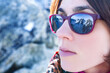 A young woman takes in the breathtaking French Alps, reflected perfectly in her goggles.