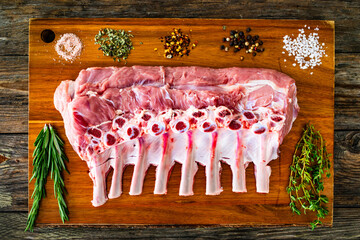 Sticker - Raw veal ribs on cutting board on wooden table
