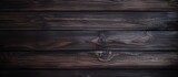 Fototapeta Do akwarium - A closeup of a dark brown hardwood surface with a blurred background, showcasing the wood plank pattern in a rectangle shape. The darkness highlights the richness of the wood stain on the flooring
