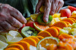 a person's hands peeling and slicing ripe fruits for a colorful and refreshing fruit salad or fruit platter