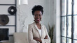 © VK Studio - Confident businesswoman smiling in a modern office setting.