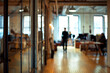 blurred people in isolated office area with windows, back button focus, day time
