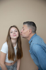 Wall Mural - proud daddy, father is posing with his daughter in front of brown background