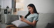 Selective focus ,Happy young woman sitting on sofa enjoy using mobile phone for online shopping cashless in living room at home