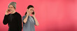 © serhii - couple of satisfied joyful young people students talking using smartphones on a pink background with free space for text horizontal frame