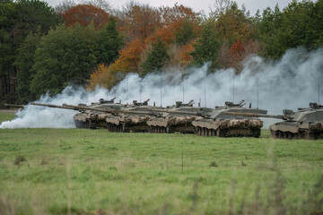 a squadron of British army FV4034 Challenger 2 ii main battle tanks preparing for a military exercise as a smoke grenade is fired