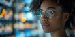 © Iryna - An intelligent black woman, an analytics professional, exudes smart elegance with stylish glasses and focus.