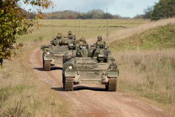 close-up of a pair of British army Warrior FV510 Infantry Fighting Vehicles in action on a military exercise