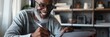 Elderly african american  man freelancer  with headphone, hands holding stylus pen and working on digital tablet pc at home.  Portrait of senior man writing making notes on tablet computer 