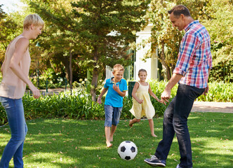 Canvas Print - Parents, children and ball in park as family, playing and bonding together with sport. Kids, son and daughter with mother and father in nature for leisure, childhood development with happiness