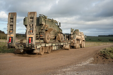 British army Foxhound 4x4-wheel drive protected patrol vehicle on a low loader trailer behind a British army MAN SVR (Support Vehicle Recovery) 8x8 Truck, Wiltshire UK