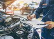 Auto check, car service shop concept. Automobile repairman writing job checklist on clipboard, mechanic checking engine to estimate repair machine, inspecting maintenance by engineer at vehicle garage
