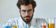 An earnest young scientist scrutinizes colorful liquids in test tubes in a lab