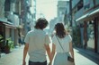 a young couple in white clothes walks through the city.  back view.