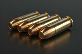 Fototapeta Na sufit - Four gold bullets are lined up on a black background