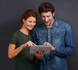 Poster - Happy couple, typing and communication with tablet for research or networking on a dark studio background. Young man and woman with smile on technology for online search, browsing or scrolling on app