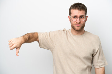 Wall Mural - Young caucasian man isolated on white background showing thumb down with negative expression